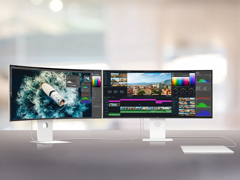 Două monitoare UltraFine sunt așezate unul lângă altul, conectându-se unul la celălalt prin intermediul unui laptop. Stația de lucru arată cât de bine sunt conectate toate dispozitivele.	