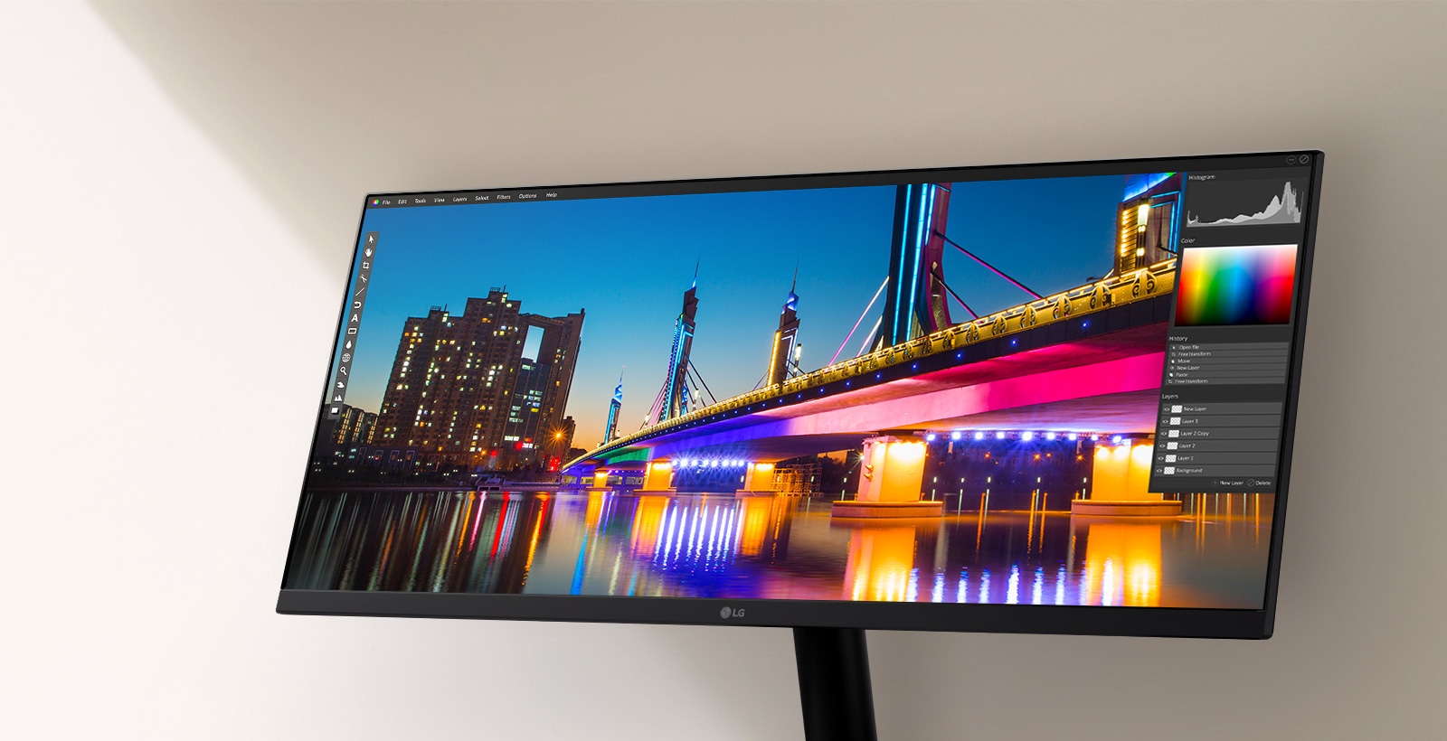 Monitor LG ultra-larg care afișează un peisaj urban nocturn intens, cu un pod luminat puternic și o reflexie, prezentat în cadrul unei interfețe software de editare foto care evidențiază instrumentele de culoare și contrast.	