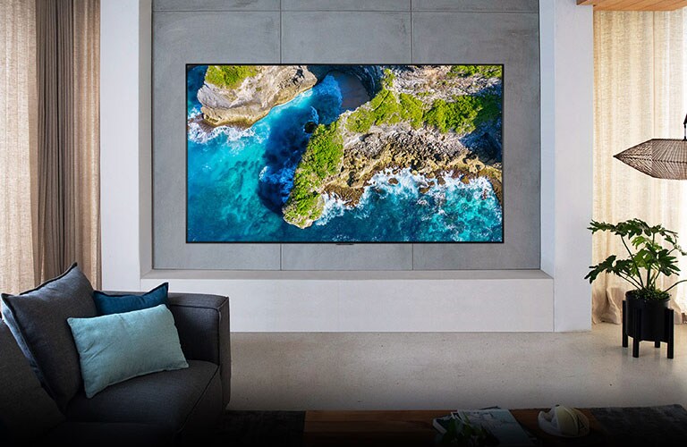 Televizor care prezintă o vedere aeriană a naturii într-un decor cu o casă luxoasă