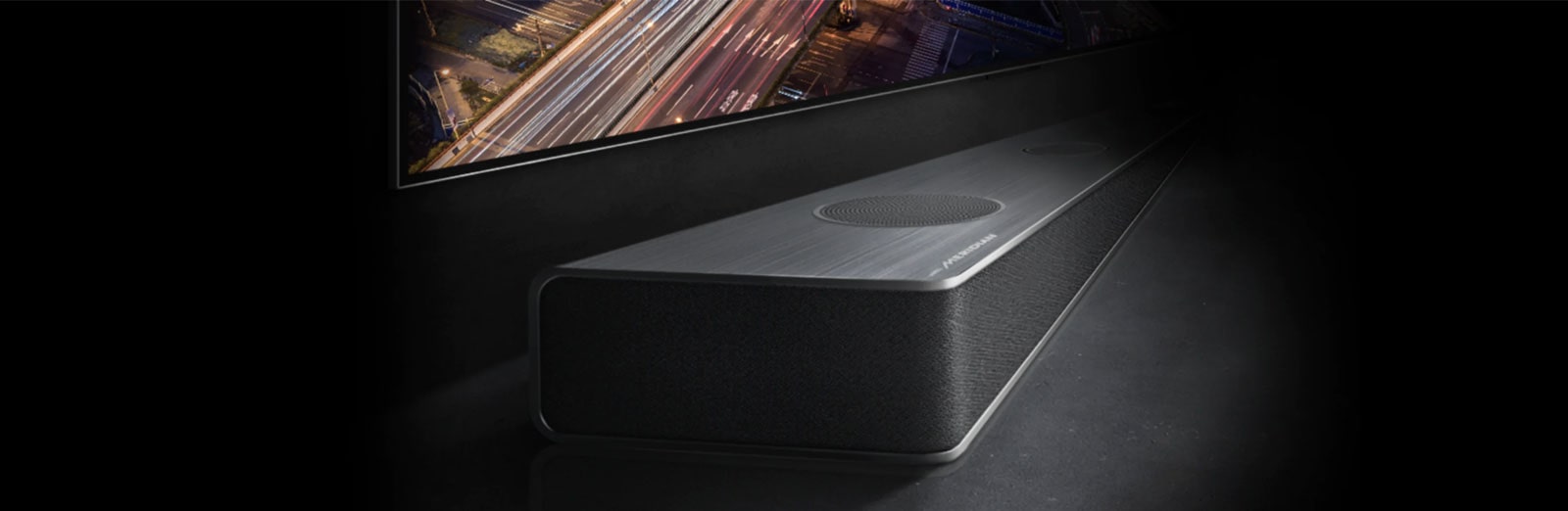 Marginea barei de sunet este vizibilă subtil sub ecranul televizorului, cu vederea drumului pe timp de noapte.