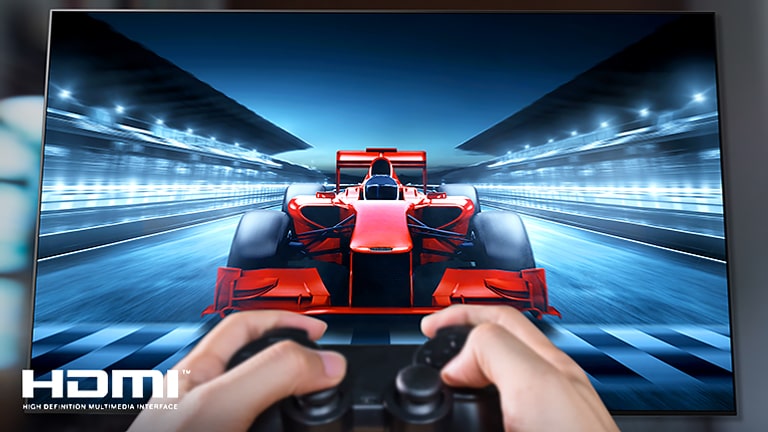 Крупный план игрока, играющего в гоночную игру на экране телевизора. На изображении в левом нижнем углу изображен логотип HDMI.