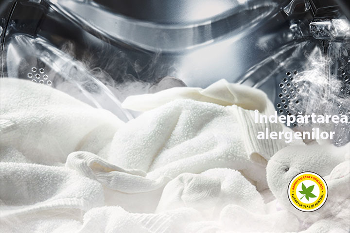  Este prezentat un halat alb moale și o jucărie de pluș, în timp ce aburul este prezent în tamburul mașinii de spălat.