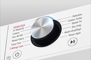 Aceasta este o imagine mărită a butonului din metal de pe panoul unei mașini de spălat.