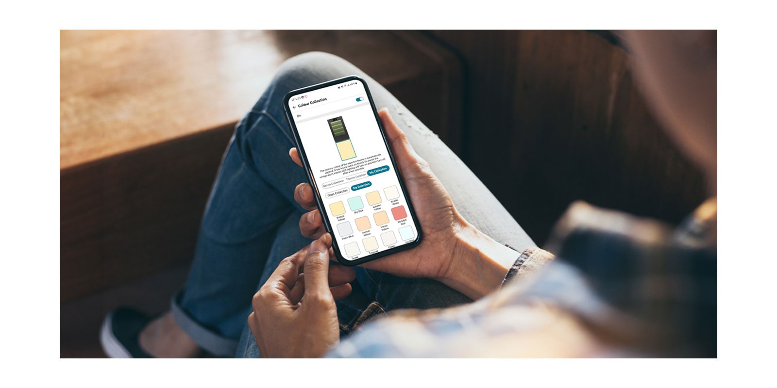 Imagine care prezintă o aplicație care vă permite să manipulați frigiderul în telefonul ținut în mână.