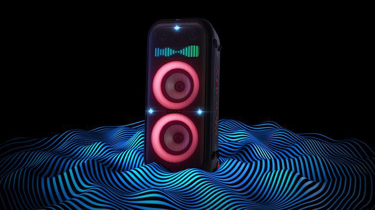 LG XBOOM XL9T stă în spațiul infinit. Iluminarea roșie a woofer-ului și luminile x-flash sunt aprinse. Deasupra difuzorului este afișat un egalizator de sunet. Undele sonore ies din partea de jos a difuzorului, pentru a-i sublinia basul profund.