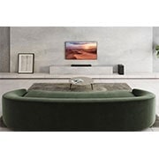 LG Soundbar LG S75Q, O bară de sunet este plasată sub televizor într-o cameră de zi albă, difuzorul spate plasat chiar lângă aceasta, S75Q, thumbnail 4