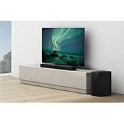 LG Soundbar LG S75Q, O bară de sunet și un televizor sunt plasate pe un raft bej, difuzorul spate plasat chiar lângă acestea, S75Q, thumbnail 5