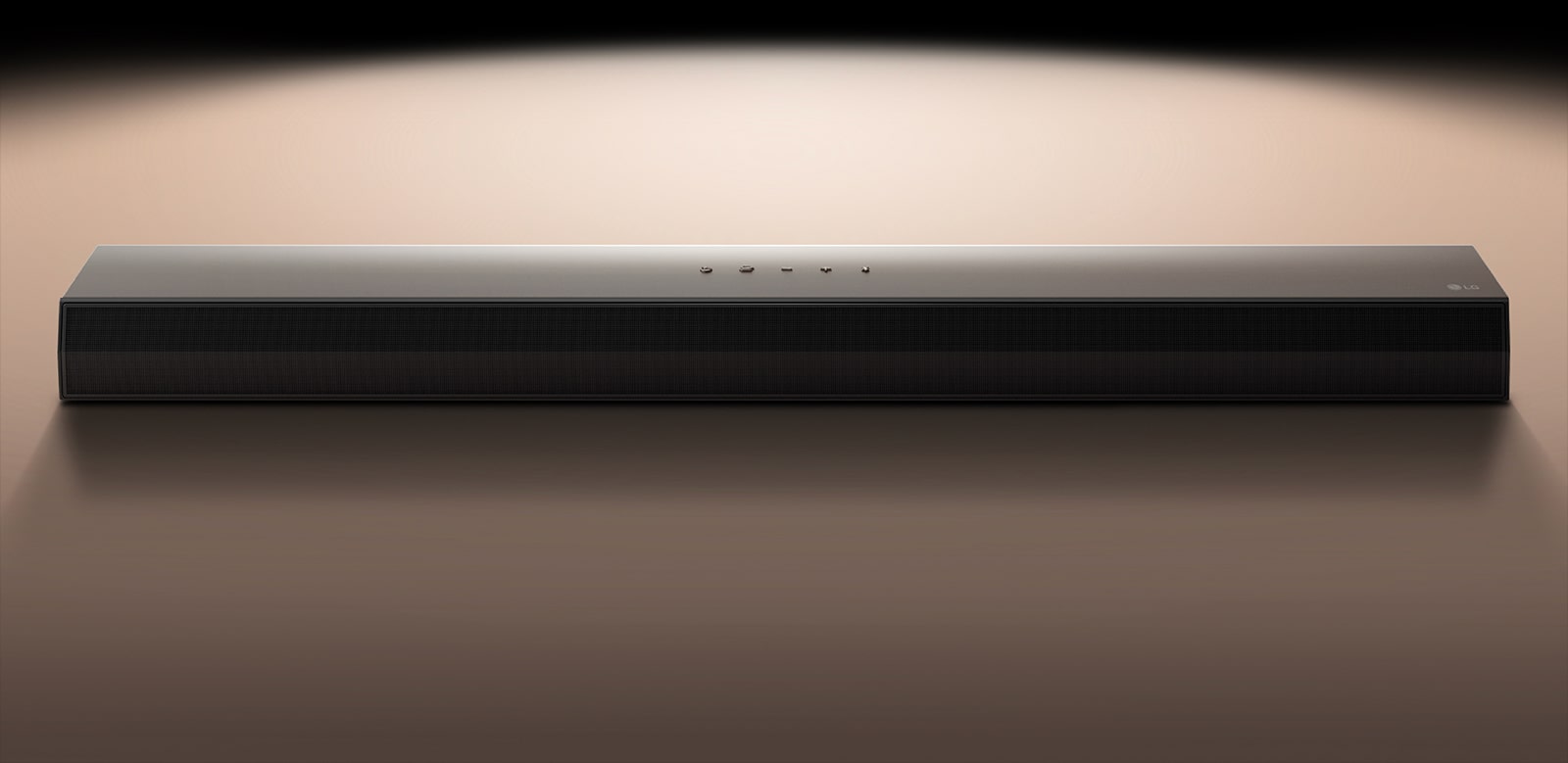 Soundbarul LG, pe un fundal negru, evidențiat de un proiector de lumină.