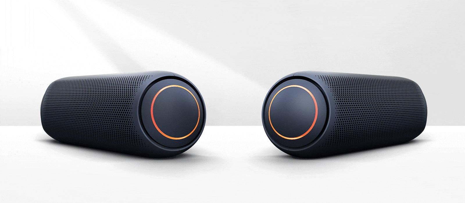 Pe fundal alb, două XBOOM Go arată unul spre altul. Ambele au iluminare de culoare roșie.