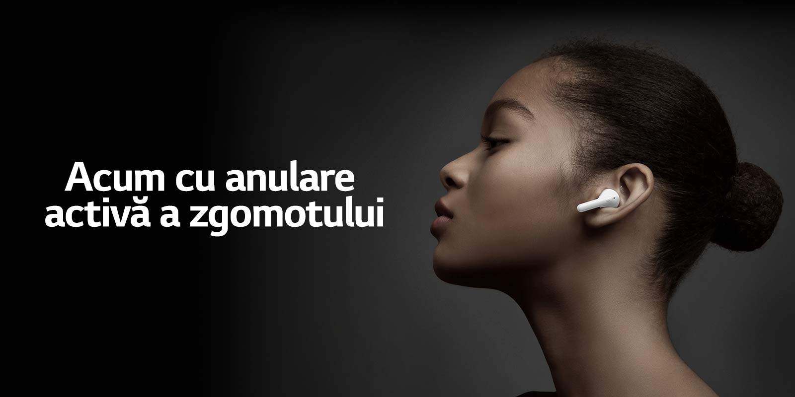 Side view of woman holding LG TONE Free against a dark background.