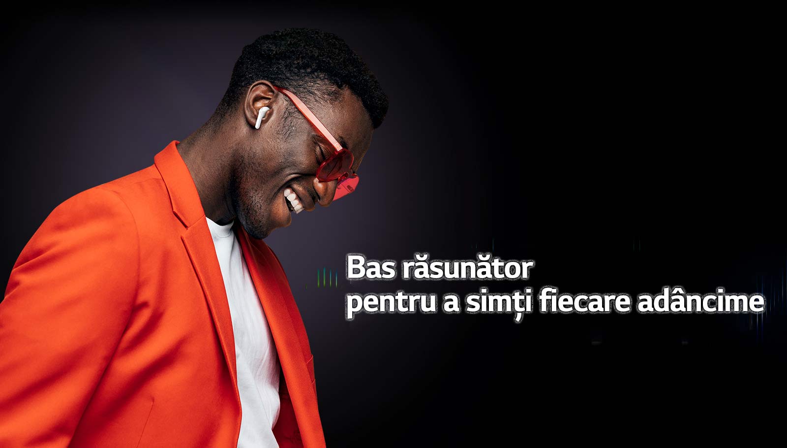 Un bărbat în costum portocaliu ascultă muzică cu TONE Free.