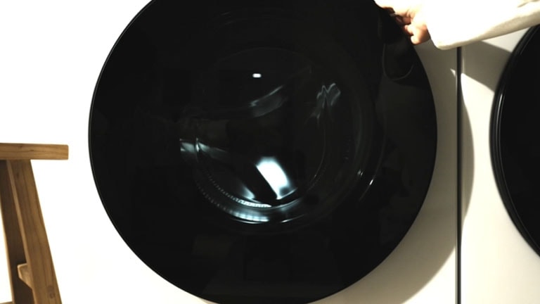 Un videoclip cu deschiderea ușii, încărcarea rufelor în tamburul încăpător și pornirea mașinii.