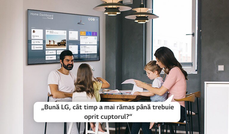 Familie stând la masă și mama întrebând televizorul cât timp mai trebuie să stea cuptorul aprins.