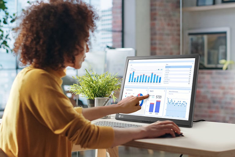 O femeie atinge un monitor tactil LG SXGA.