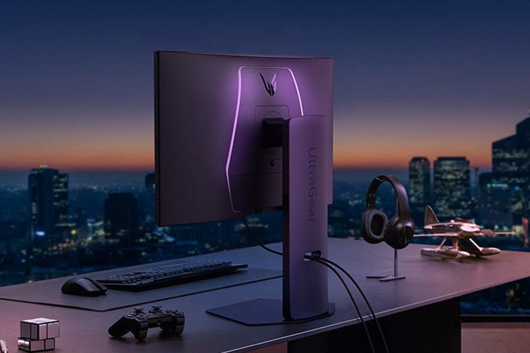 Vedere din spate a unui monitor cu accente LED pe un birou.