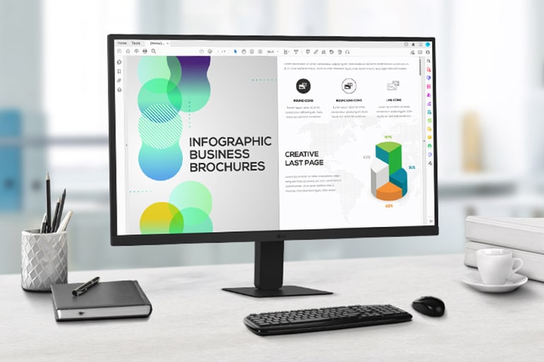Pe birou este un monitor QHD IPS care afișează lucrul la un document. Alături de monitor sunt un suport pentru pixuri, un jurnal, un pix, o tastatură și un pahar.