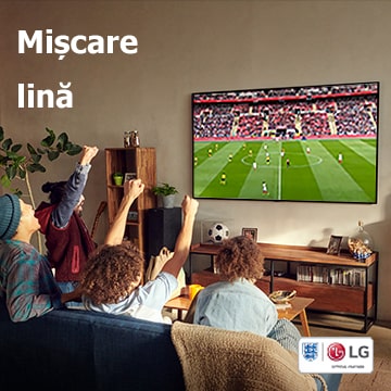 Patru oameni stau pe canapea și urmăresc un joc de fotbal în sufragerie.