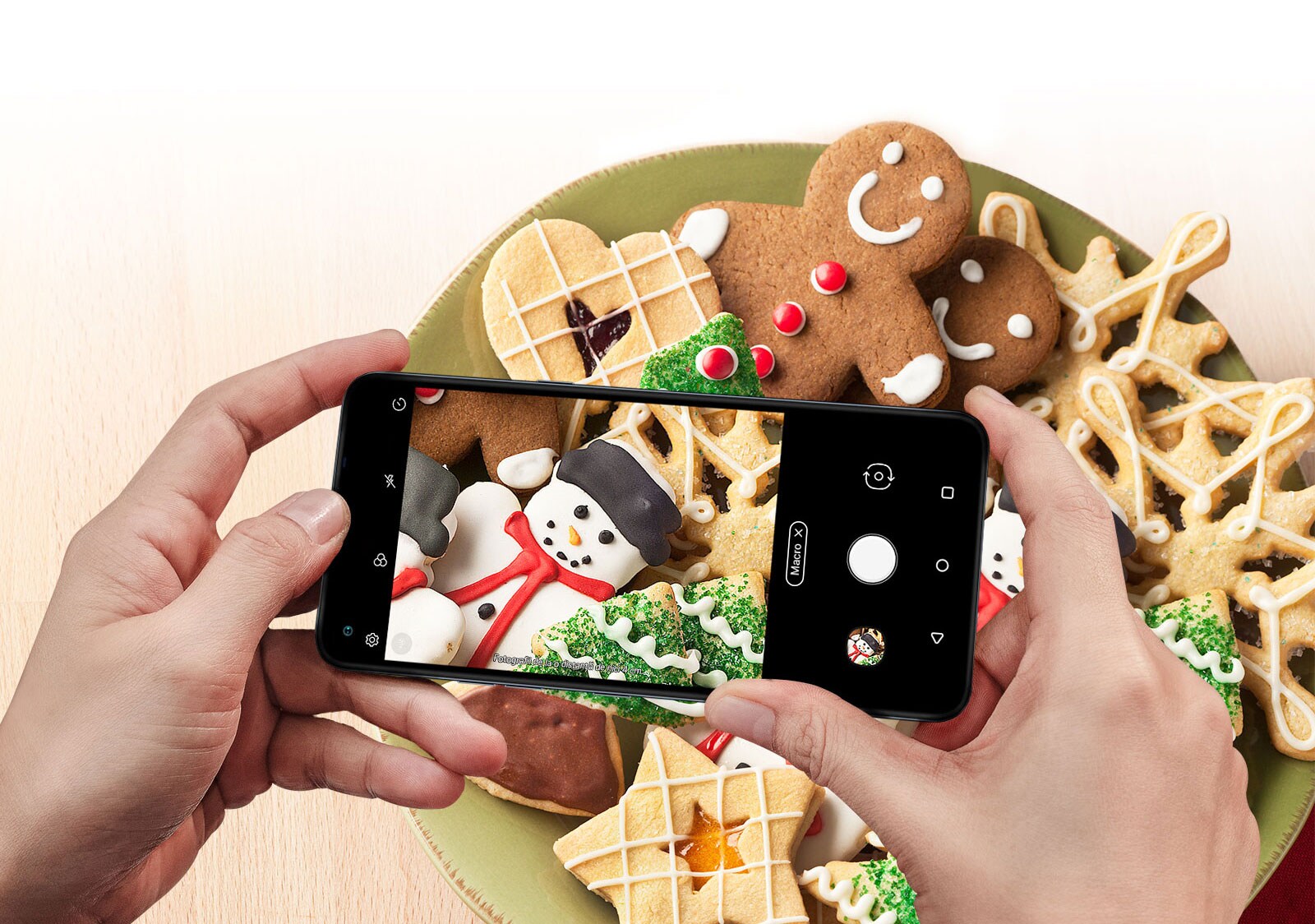 Imagine de aproape a unei persoane care fotografiază prăjituri cu un smartphone.