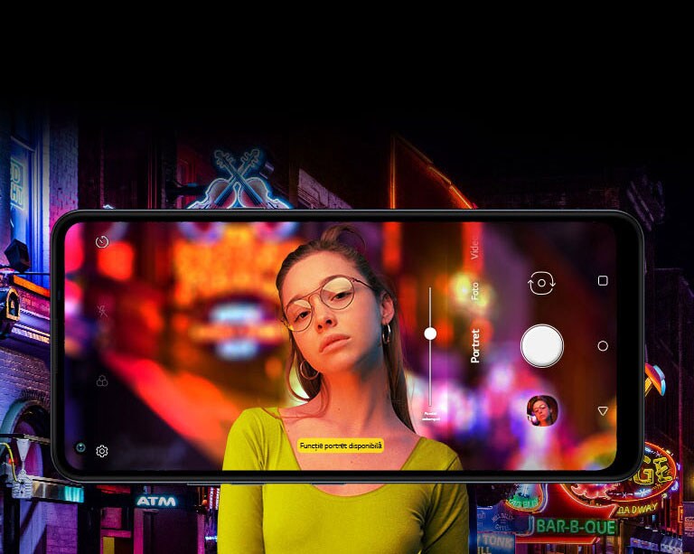 O femeie care își face un selfie în stradă, pe un fundal plin de lumini.