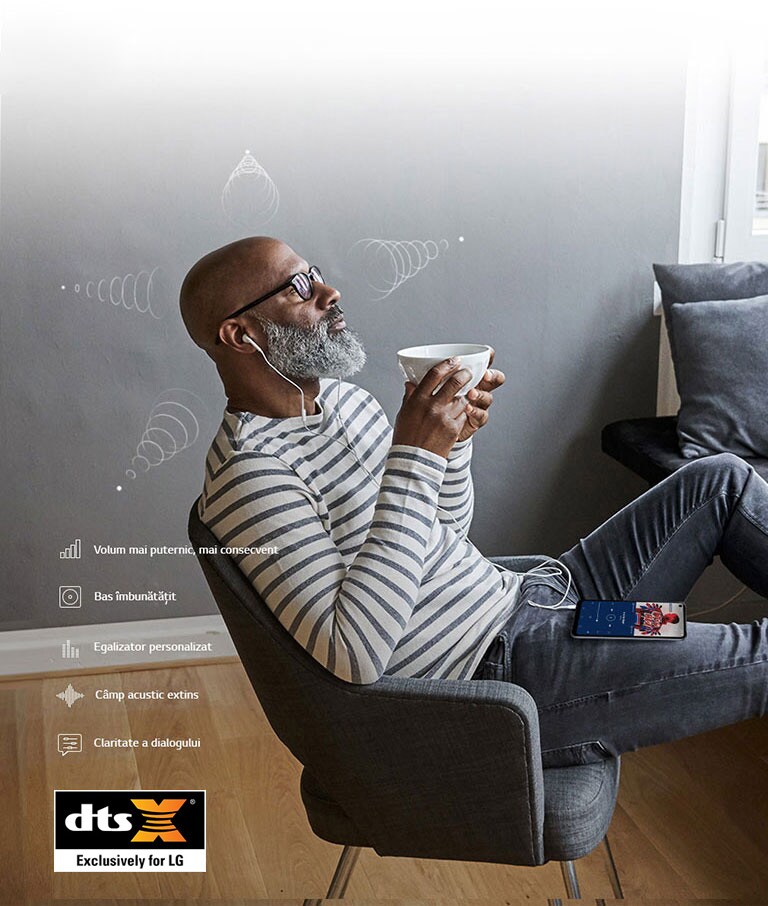 Un bărbat așezat pe un scaun, care bea cafea și asculta muzică în căști