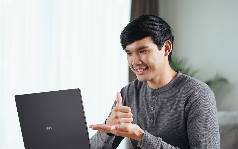 A man uses a laptop as assistive technology.