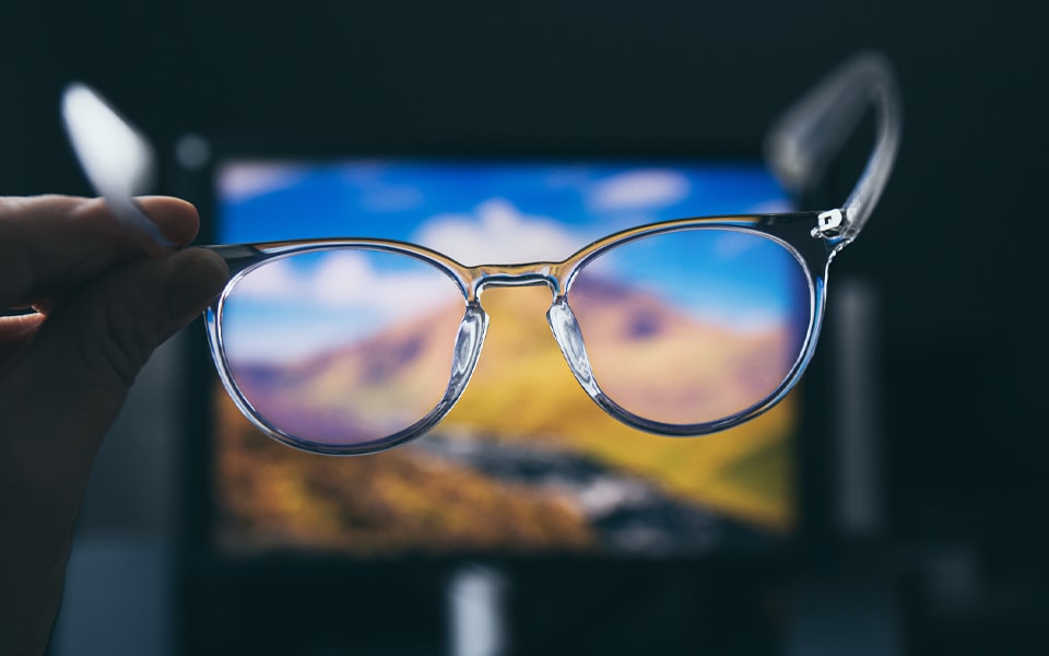 A photo of a person holding glasses in their hand