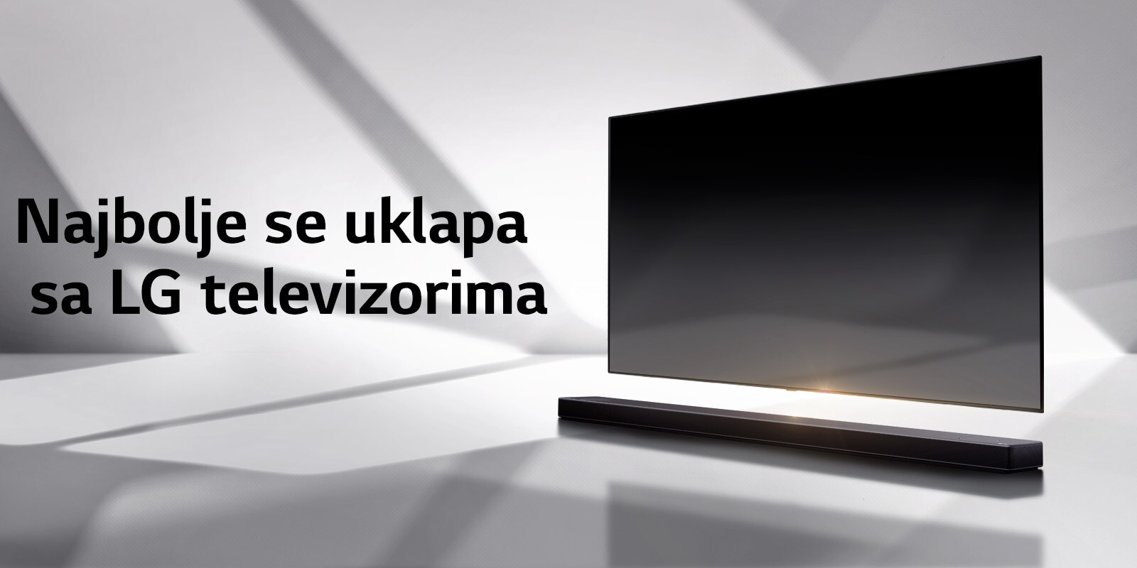 Soundbar zvučnik i TV postavljeni su na belom podu, a odmah iza pojavljuje se senka.