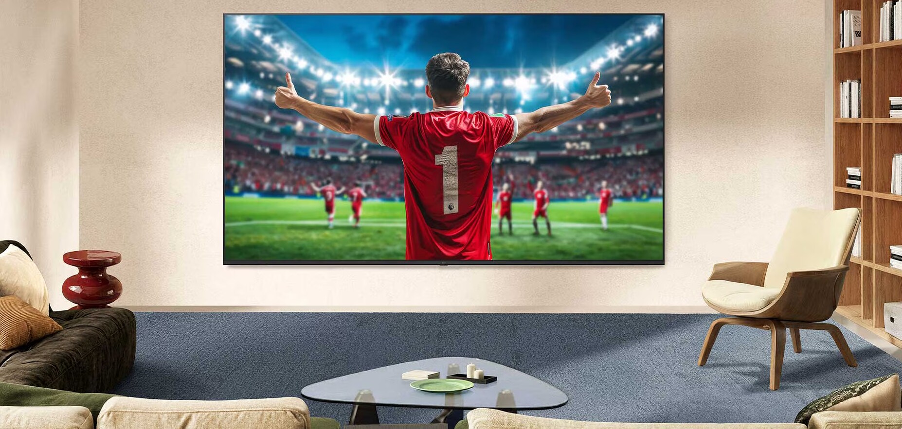 LG NANO 4K UHD AI NU80 ultraveliki TV ekran montiran je na zid u prostoriji i prikazuje proslavu fudbalera na sredini stadiona pod jakim svetlima arene, čime se naglašavaju živopisne boje, jasnoća i impresivna razmera.