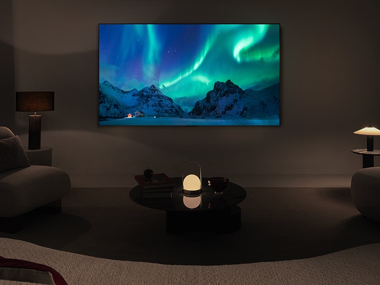 LG OLED TV i LG soundbar u savremenom životnom prostoru tokom noći. Na ekranu je prikazana slika polarne svetlosti na idealnom nivou osvetljenosti.