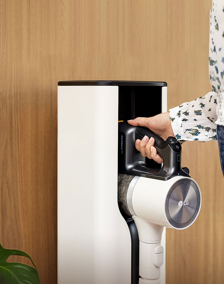 Žena stavlja LG Cordzero™ usisivač u priključnu stanicu.