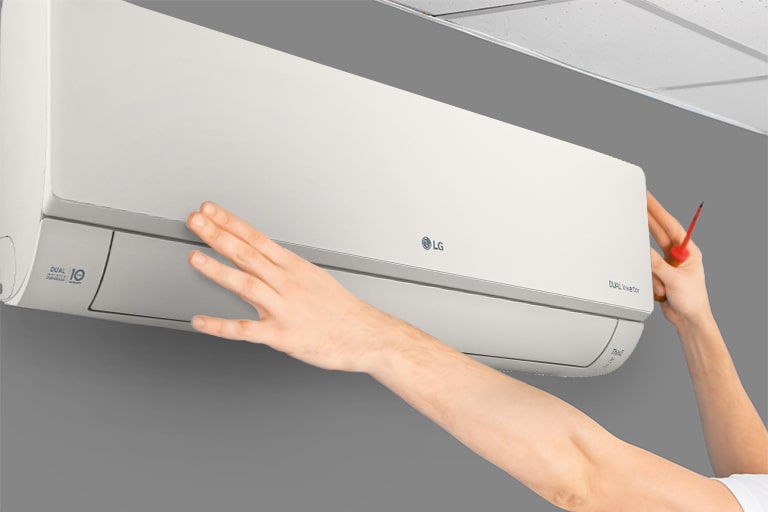 Bočni prikaz klima uređaja na zidu. Dve ruke posežu nagore, jedna drži alat i pokazuje se lakoća instalacije.