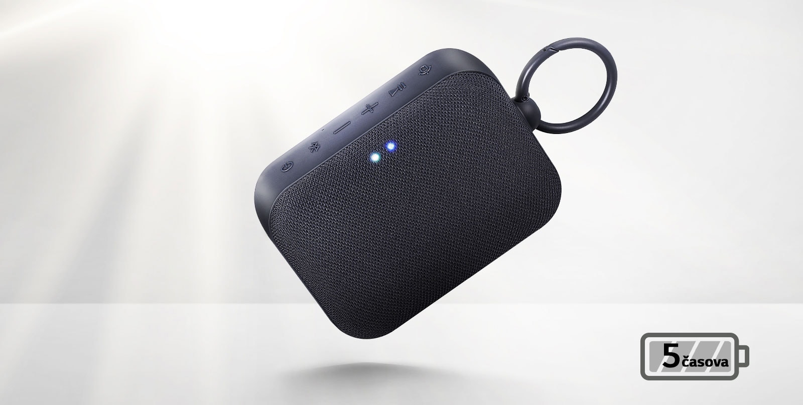 Prikaz zvučnika LG XBOOM Go spreda kako lebdi pod uglom. Svetlost dolazi otpozadi.