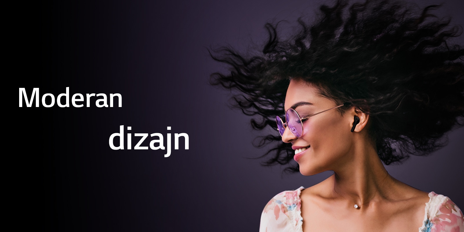 Žena se smeši dok sluša muziku preko TONE Free bubica.