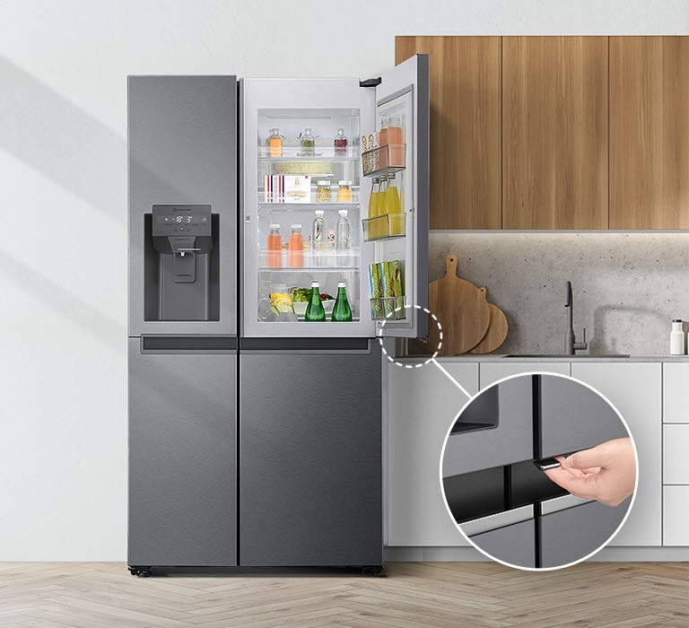 Pogled na frižider sa prednje strane u kuhinji.  Gornja desna vrata su otvorena, sa krugom u uglu, linijom koja vodi do većeg kruga koji pokazuje uvećan pogled na krug u donjem levom uglu otvorenih vrata sa skrivenim dugmetom za otpuštanje.