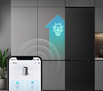 LG frižider sa donjim zamrzivačem i pametnim telefonom koji prikazuje ThinQ™ aplikaciju ispred, uz svetleću plavu AI ikonu pored frižidera.