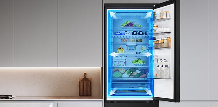 LG frižider sa donjim zamrzivačem i otvorenim vratima, hrana u odeljku frižidera, plava boja i strelice ilustruju prostran enterijer.