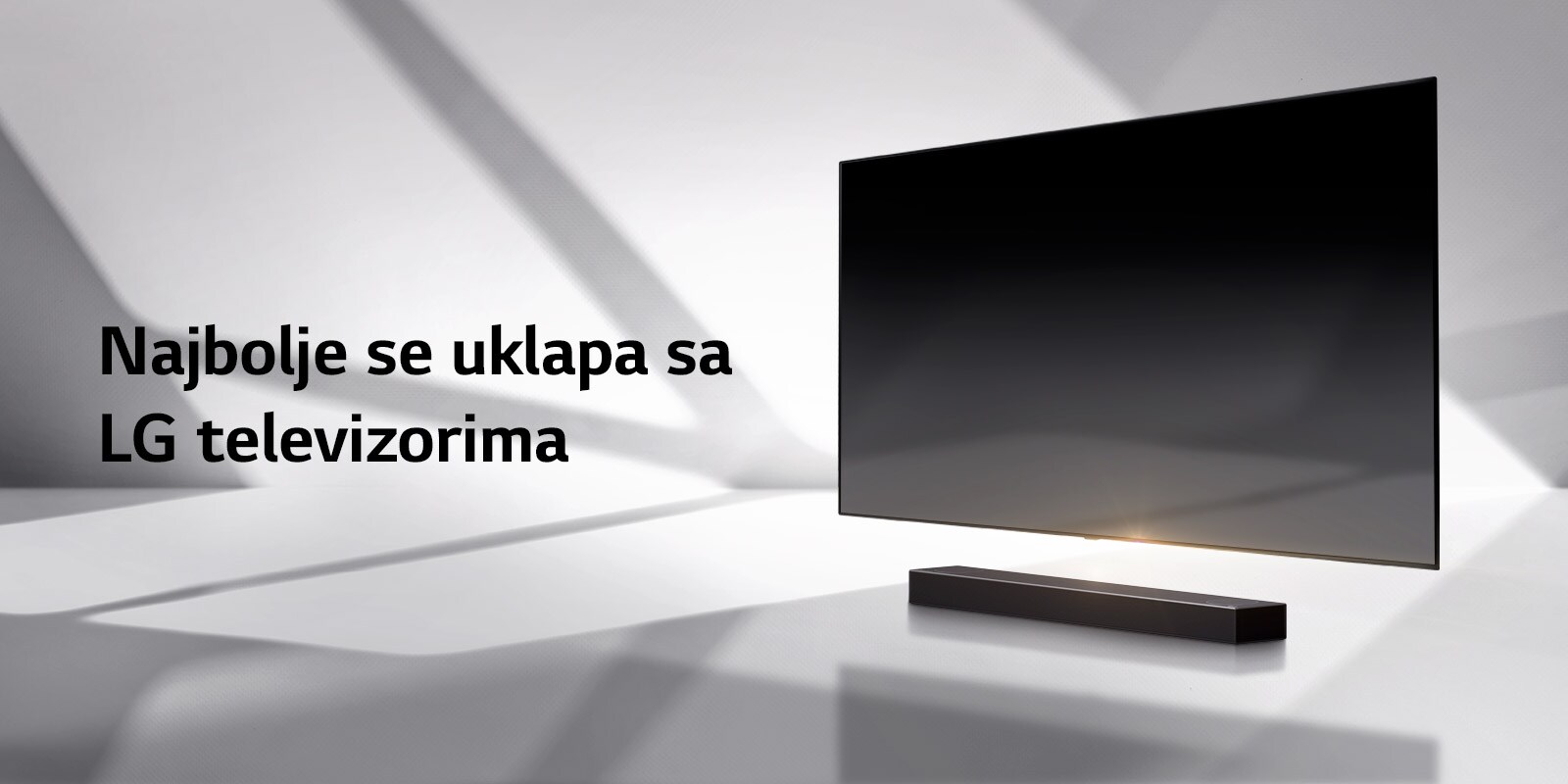 Soundbar zvučnik i TV postavljeni su na belom podu, a odmah iza pojavljuje se senka.