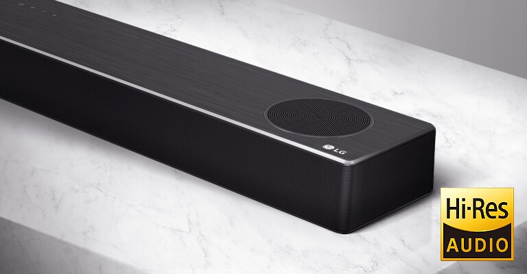 Prikaz desne strane LG Soundbar zvučnika izbliza sa logotipom LG u donjem desnom uglu proizvoda.