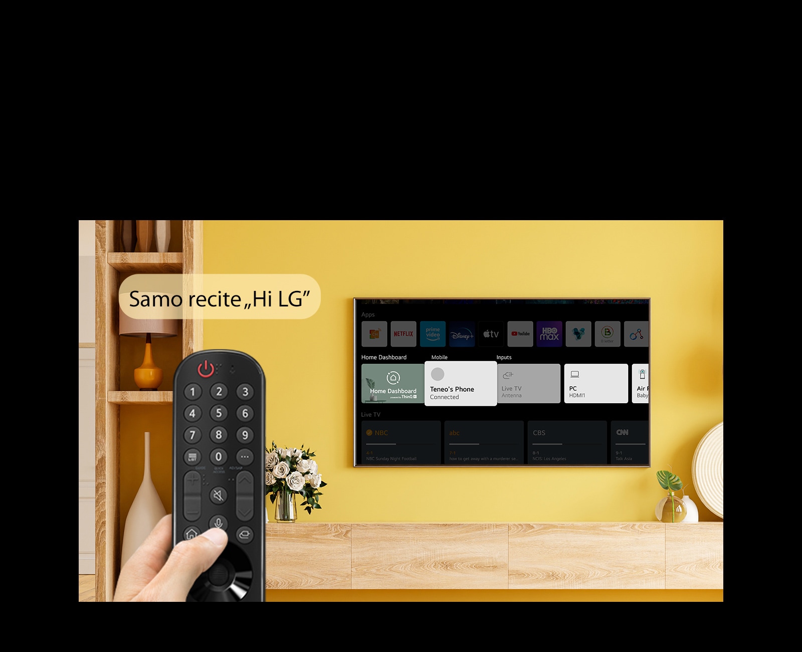 Neko drži daljinski upravljač televizora ispred TV ekrana. U balončiću za govor stoji „Just say Hi LG”.