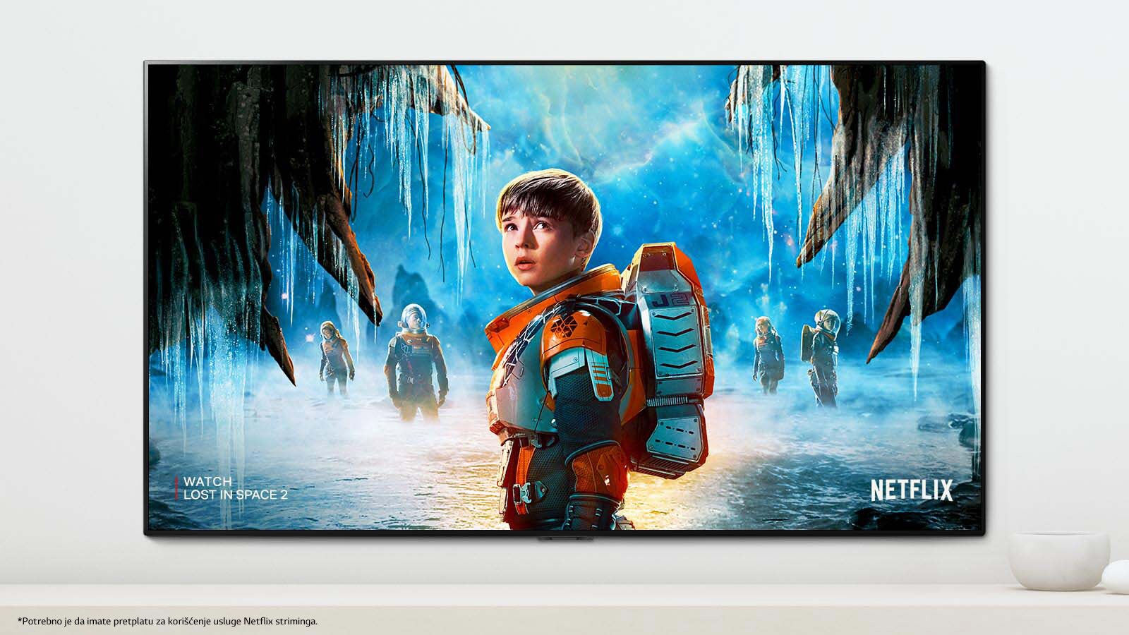 Scena iz serije "Izgubljeni u svemiru 2" u kojoj se prikazuju glavni junaci sa dramatičnim izrazima lica na TV ekranu