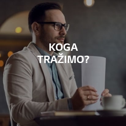 Muškarac sedi za stolom i drži svežanj papira