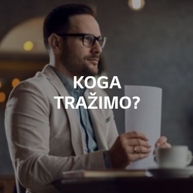 Muškarac sedi za stolom i drži svežanj papira