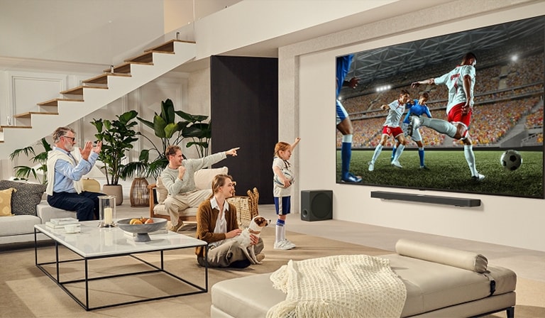 Porodica okupljena oko LG Ultra Big TV-a gleda uzbudljivu fudbalsku utakmicu na ogromnom ekranu. 