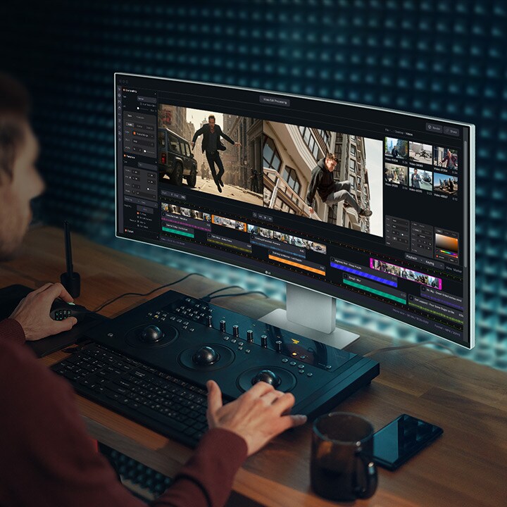 Muškarac radi u programu za montažu videa na UltraFine monitoru.
