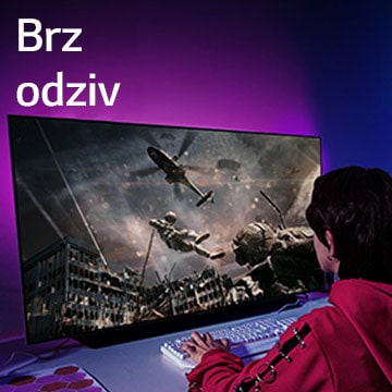 Devojka igra računarsku igru dok veliki televizor prikazuje vojnika koji silazi iz helikoptera.