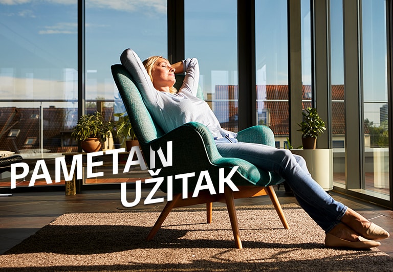 Žena se opušta na stolici u dnevnoj sobi.