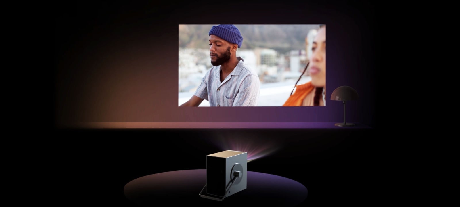 Video funkcije – scena u kojoj se projektor automatski prilagođava pošto ga žena postavi na pod.