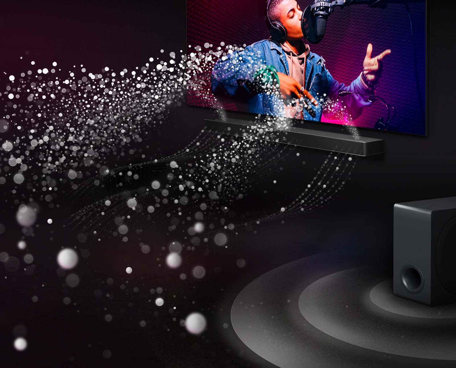 LG Soundbar i LG TV u crnoj prostoriji emituju muzički nastup. Bele kapljice koje predstavljaju zvučne talase kreću se nagore i unapred iz soundbar zvučnika. Niskotonac stvara zvučni efekat odozdo.