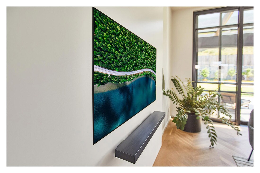 LG 65'' (165 cm) 4K HDR Smart OLED TV, Slight tilted at an angle, a living room with a TV showing an aerial view of nature, OLED65WX9LA, thumbnail 10