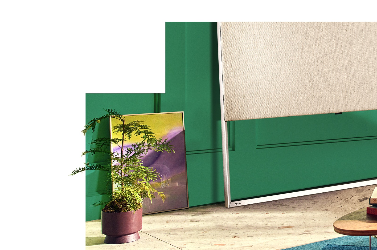 Крупный план телевизор Easel, стоящего с наклоном на полу, с живописью и декоративными растениями.